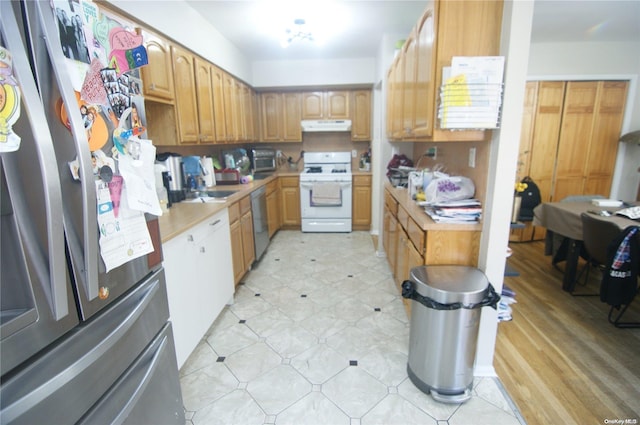 kitchen with sink, appliances with stainless steel finishes, and light hardwood / wood-style flooring