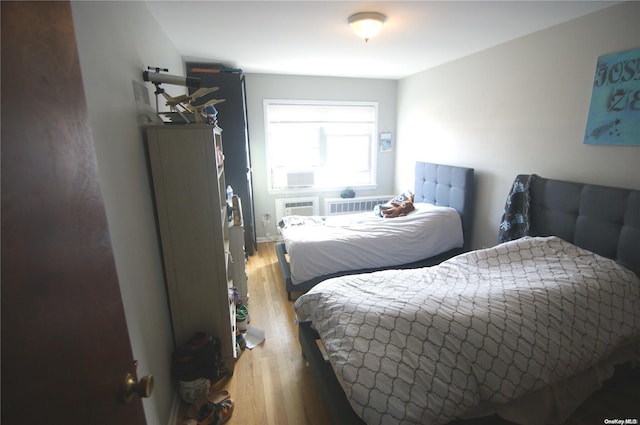 bedroom featuring an AC wall unit and light hardwood / wood-style floors