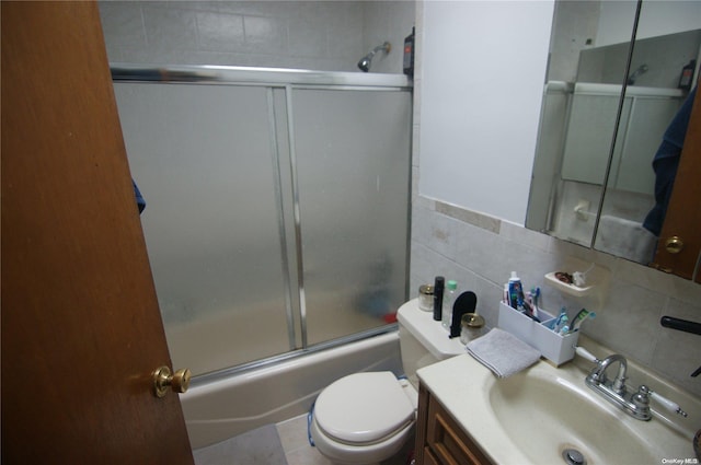 full bathroom featuring tasteful backsplash, tile patterned floors, vanity, enclosed tub / shower combo, and toilet