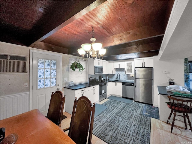 kitchen featuring beam ceiling, sink, stainless steel appliances, light hardwood / wood-style flooring, and white cabinets