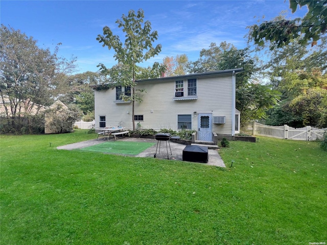 rear view of house with a lawn, a storage shed, a patio, and a wall mounted AC