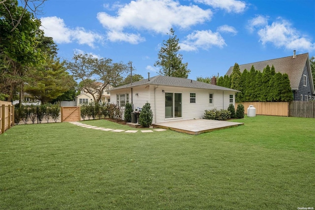 rear view of house with a deck and a lawn