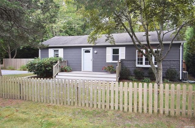 view of front of property with central AC and a front lawn