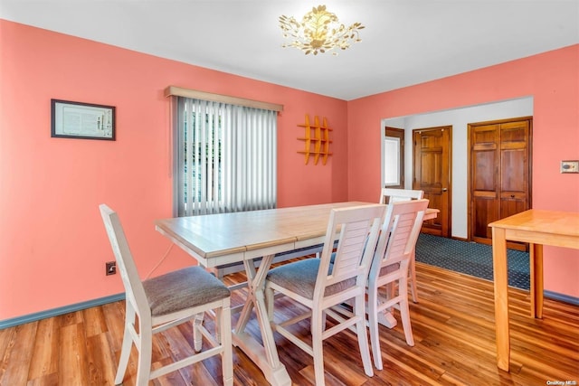 dining area with light hardwood / wood-style floors and an inviting chandelier