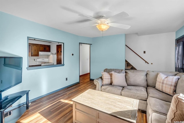 living room with dark hardwood / wood-style flooring and ceiling fan