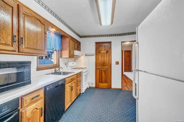 21 Fern Ter, West Babylon, NY 11704 - kitchen featuring black appliances, under cabinet range hood, light countertops, dark colored carpet, and brown cabinets