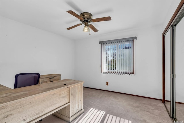 unfurnished office featuring light colored carpet and ceiling fan