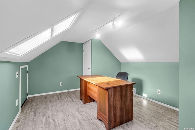 office with lofted ceiling with skylight, rail lighting, and light wood-type flooring