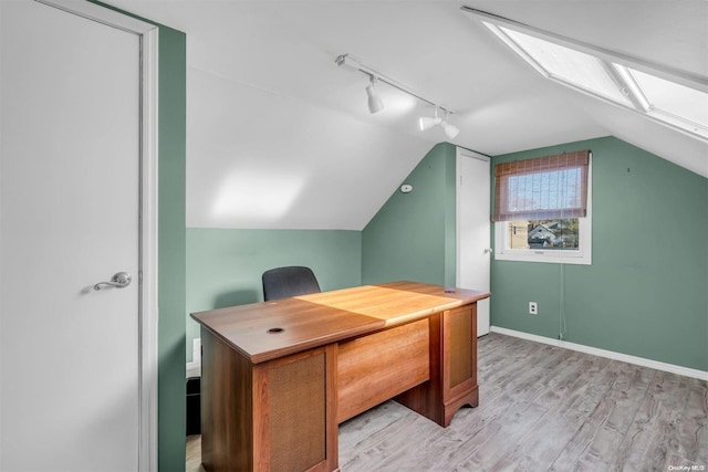 home office featuring light hardwood / wood-style floors and vaulted ceiling