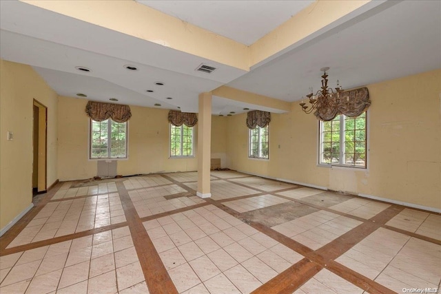 spare room featuring a notable chandelier and light tile patterned floors