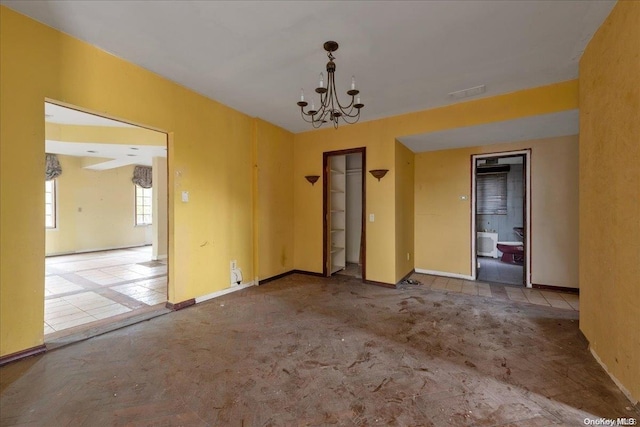 carpeted spare room featuring a chandelier