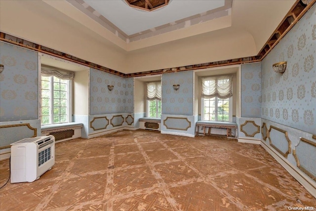 interior space with a tray ceiling and heating unit