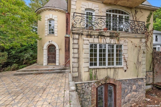 property entrance with a balcony and french doors