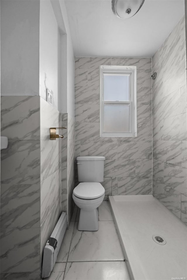 bathroom featuring tiled shower, toilet, and tile walls