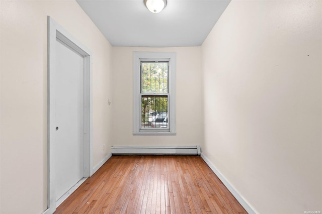 spare room featuring a baseboard radiator and light hardwood / wood-style flooring