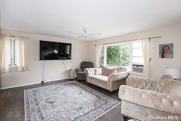 living room with ceiling fan, cooling unit, and dark hardwood / wood-style flooring