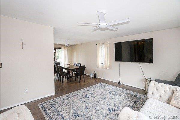 living room with ceiling fan and dark hardwood / wood-style floors