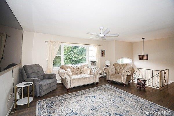 living room with ceiling fan and dark wood-type flooring