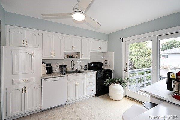 kitchen with backsplash, white dishwasher, sink, white cabinetry, and black / electric stove