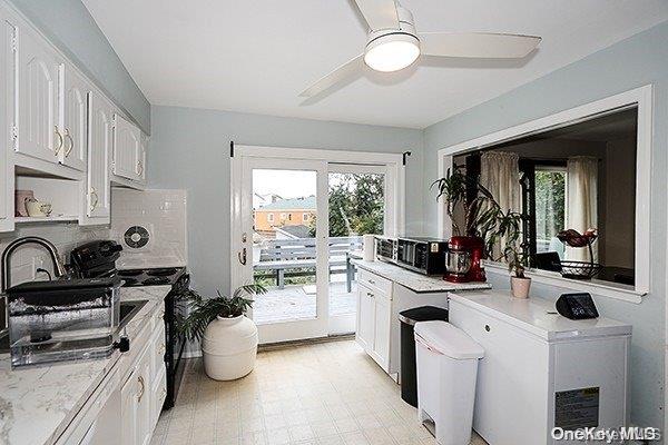 kitchen featuring white cabinets, decorative backsplash, sink, and a wealth of natural light