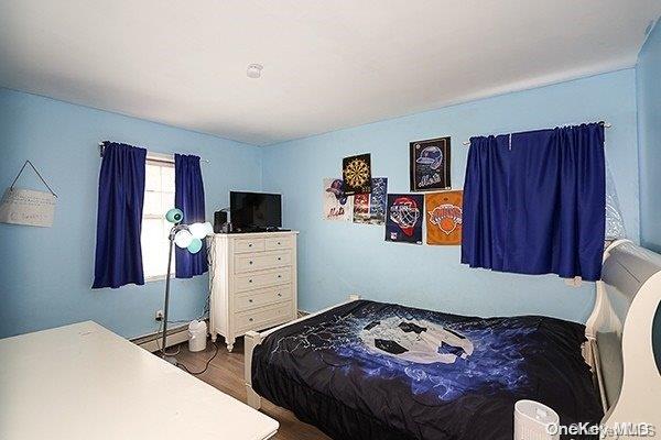 bedroom with dark hardwood / wood-style floors