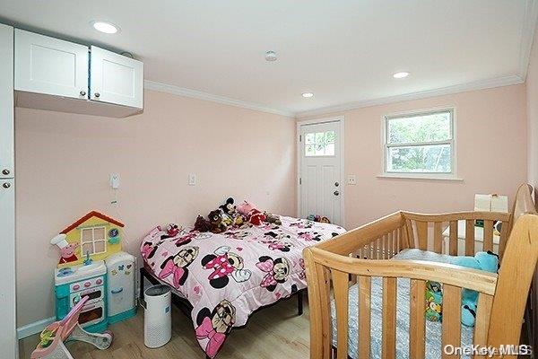 bedroom with crown molding and hardwood / wood-style floors