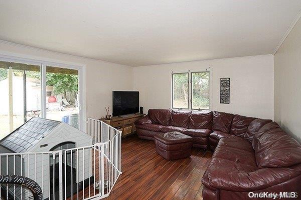 living room with dark hardwood / wood-style floors and ornamental molding