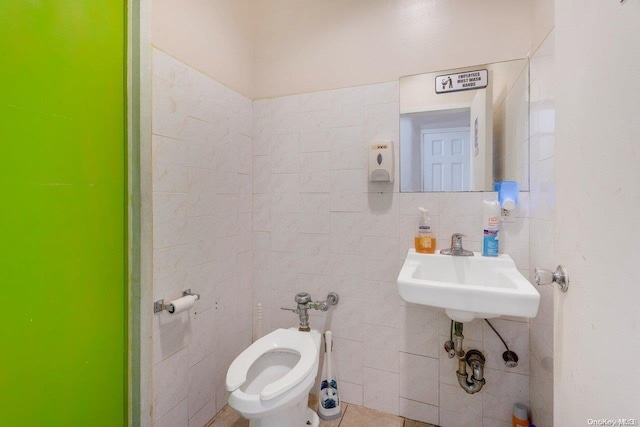 bathroom with sink, tile walls, and toilet