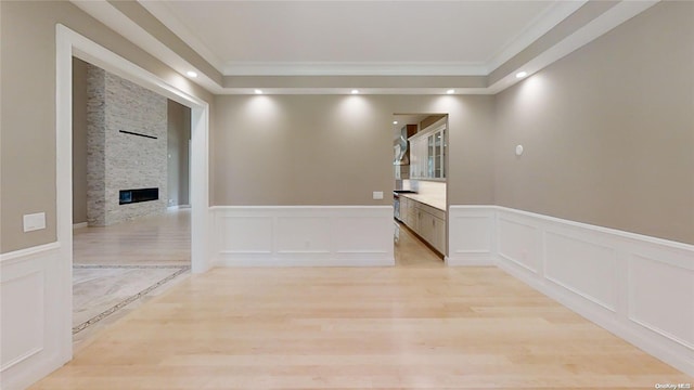 hallway with light hardwood / wood-style floors and ornamental molding