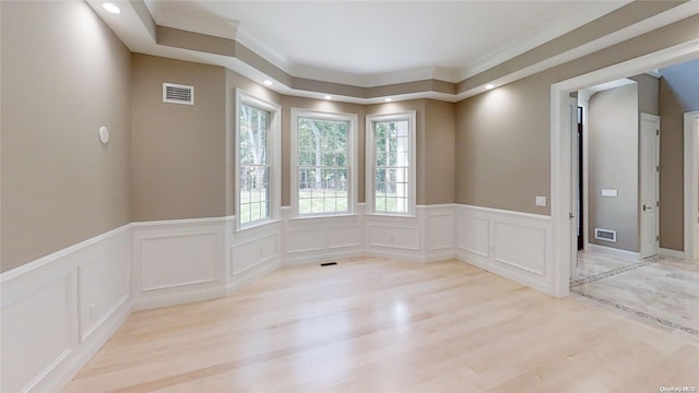 spare room with crown molding and light hardwood / wood-style flooring