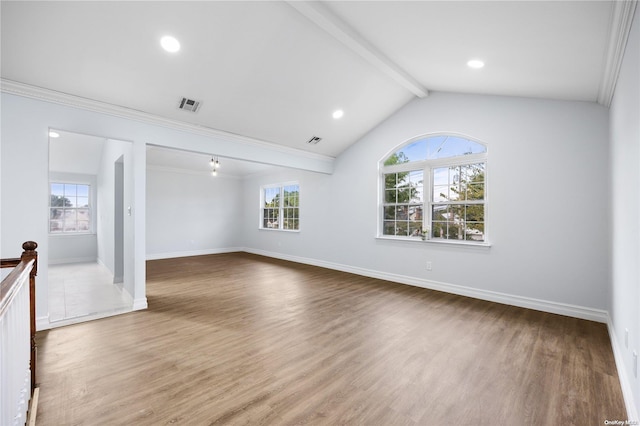 unfurnished living room with hardwood / wood-style floors, plenty of natural light, vaulted ceiling with beams, and crown molding