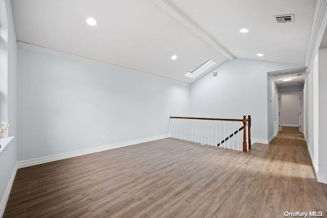 spare room with lofted ceiling with beams, hardwood / wood-style flooring, and ornamental molding