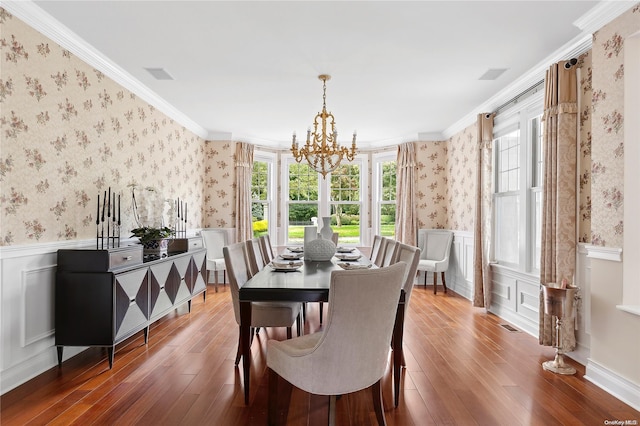 dining space featuring hardwood / wood-style floors, a notable chandelier, and crown molding