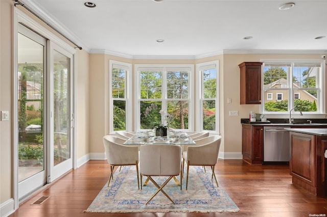 dining area featuring crown molding, dark hardwood / wood-style flooring, and sink