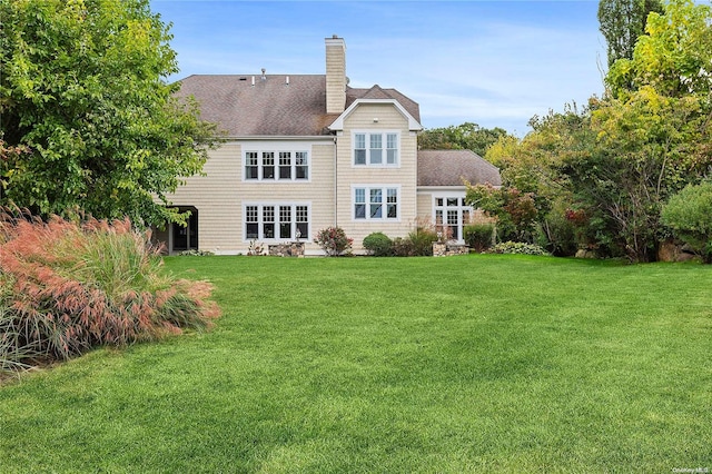 rear view of house featuring a yard