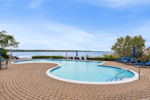 view of swimming pool with a patio and a water view