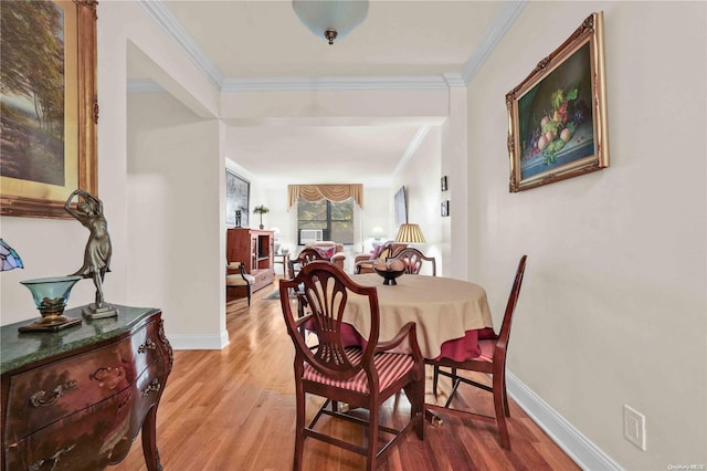 dining space featuring hardwood / wood-style floors and ornamental molding