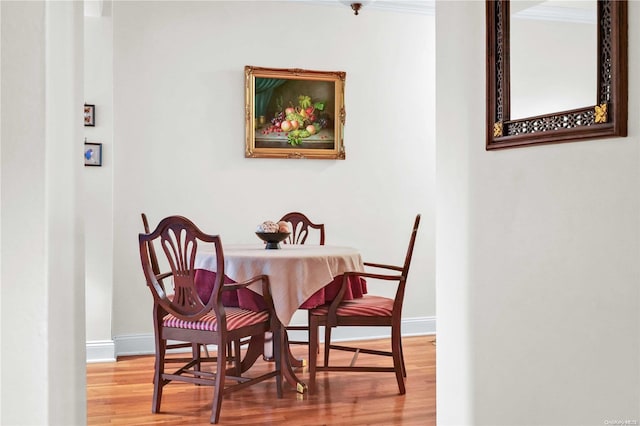 dining area featuring hardwood / wood-style floors and crown molding