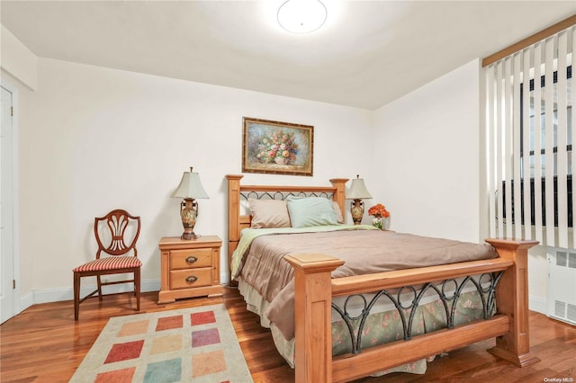 bedroom with radiator and wood-type flooring