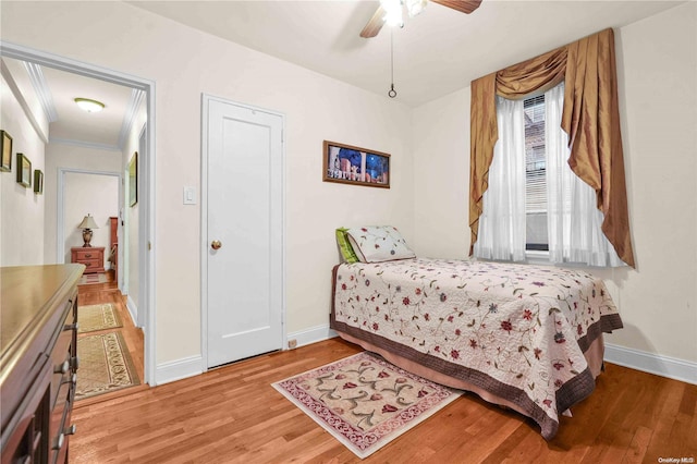 bedroom featuring hardwood / wood-style flooring, ceiling fan, and crown molding