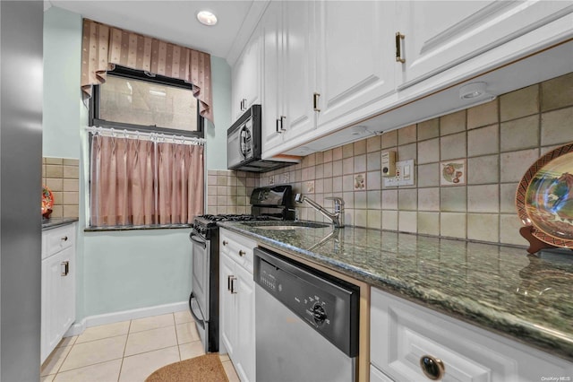 kitchen featuring backsplash, white cabinets, dark stone countertops, light tile patterned floors, and appliances with stainless steel finishes