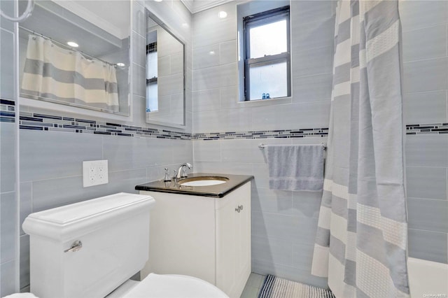 bathroom with vanity, toilet, tile walls, and curtained shower