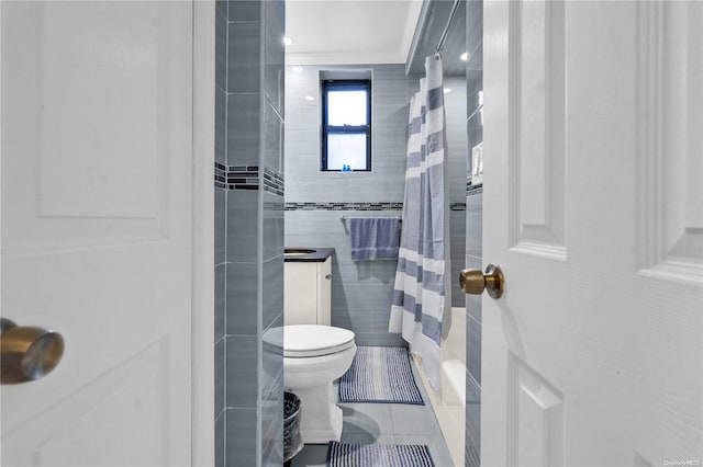 bathroom with toilet, tile patterned flooring, tile walls, and a shower with shower curtain