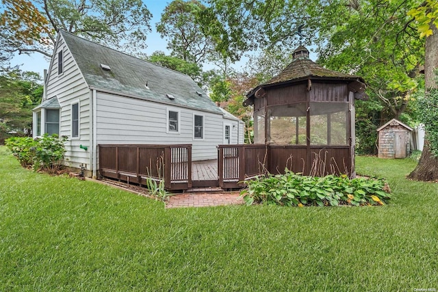 back of house with a gazebo, a shed, a lawn, and a wooden deck