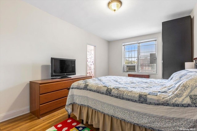 bedroom featuring hardwood / wood-style floors and cooling unit