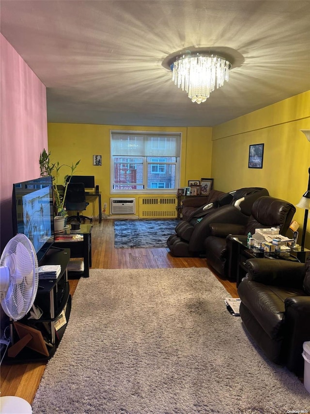 living room with radiator heating unit, wood-type flooring, and an inviting chandelier