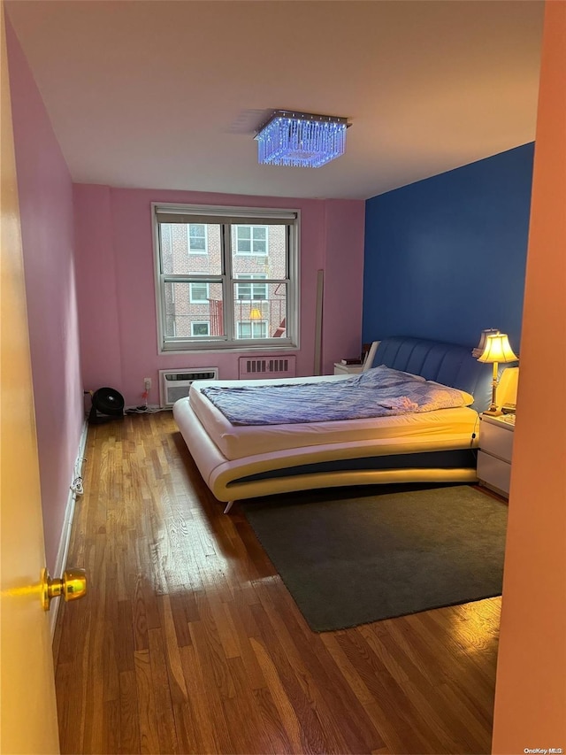 bedroom featuring a wall mounted air conditioner and hardwood / wood-style floors