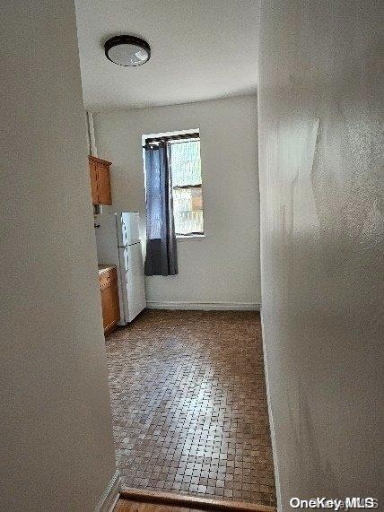 344 W 48 Unit 1Re, New York Manhattan, NY 10036 - unfurnished room with brick patterned floors and baseboards