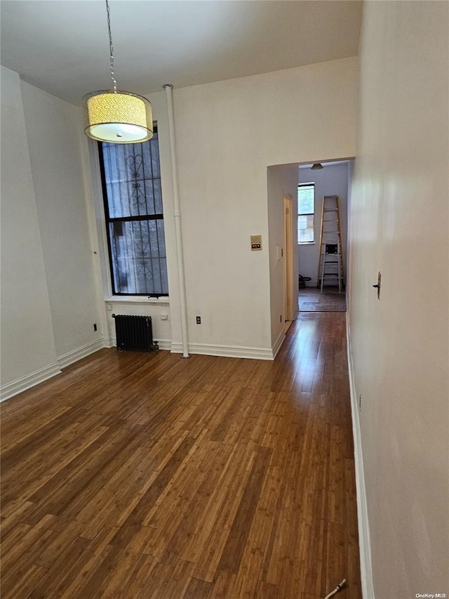 344 W 48 Unit 1Re, New York Manhattan, NY 10036 - unfurnished dining area featuring dark wood-style floors, baseboards, and radiator