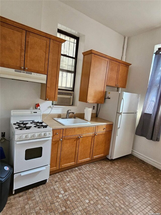 344 W 48 Unit 1Re, New York Manhattan, NY 10036 - kitchen with white appliances, under cabinet range hood, a sink, brown cabinets, and cooling unit